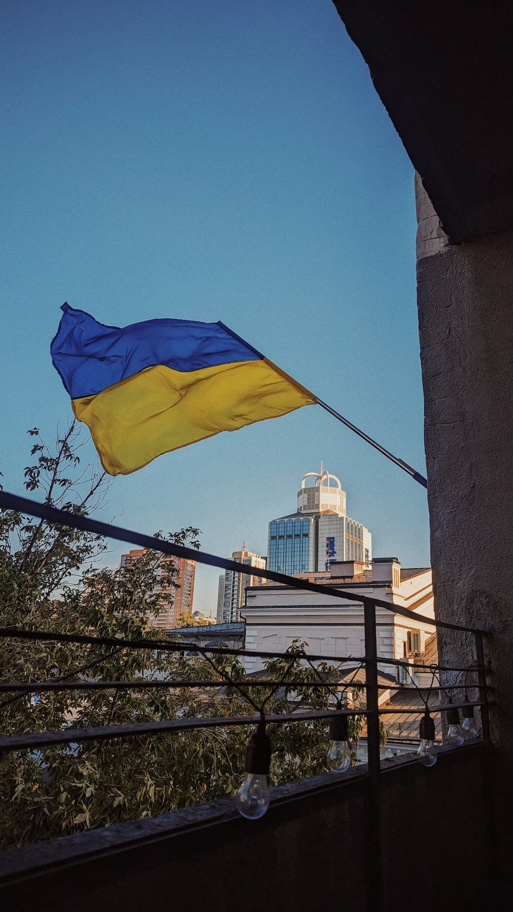 eine blau-gelbe Flagge, die von einem Balkon weht