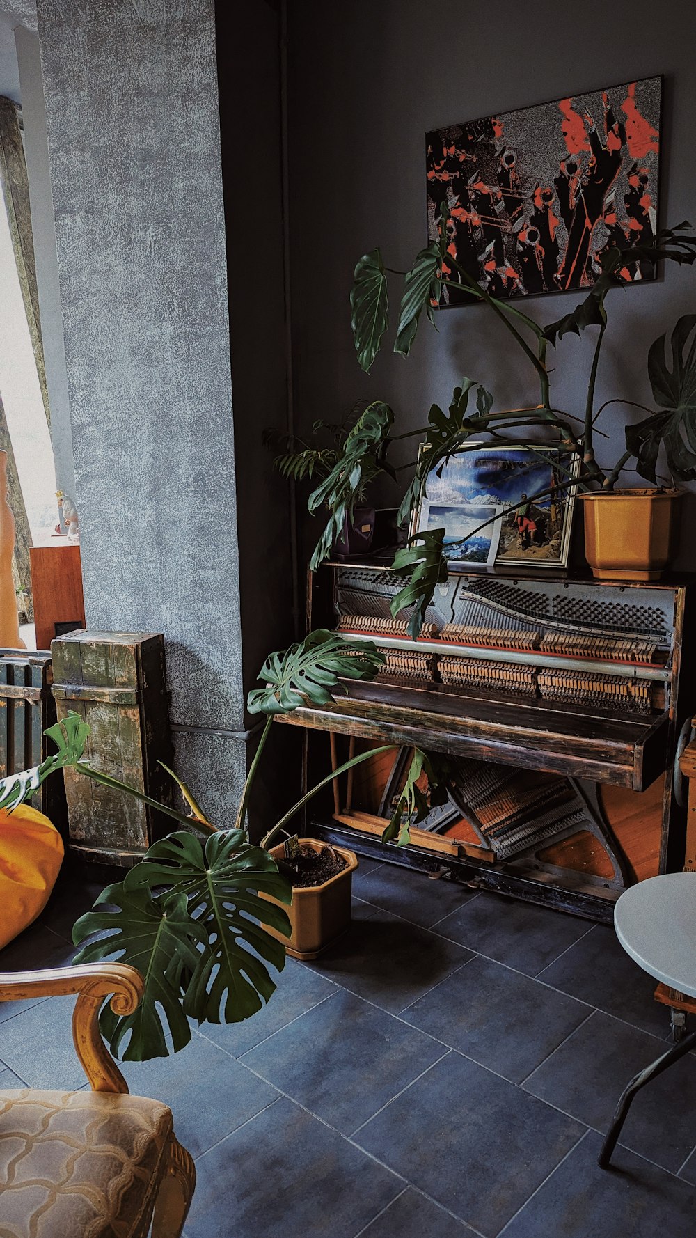 a living room with a piano and a potted plant