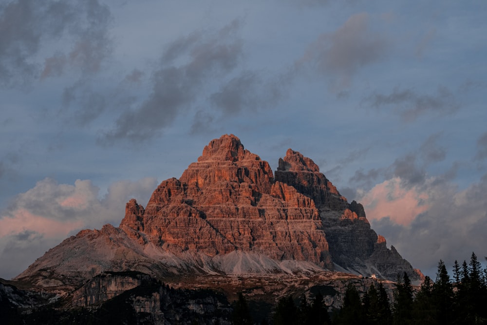 a very tall mountain with some clouds in the sky