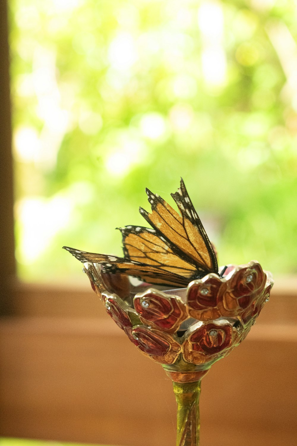 uma borboleta sentada em cima de um vaso de vidro