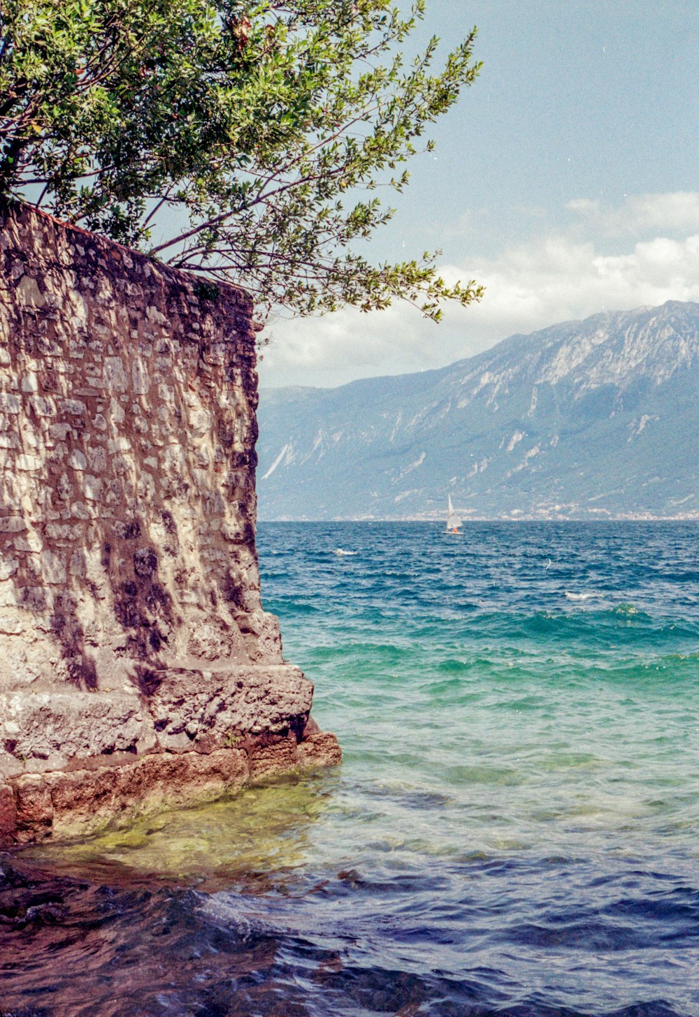 a boat is in the water near a rocky cliff