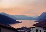 A picturesque view of a lake surrounded by mountains at sunset.