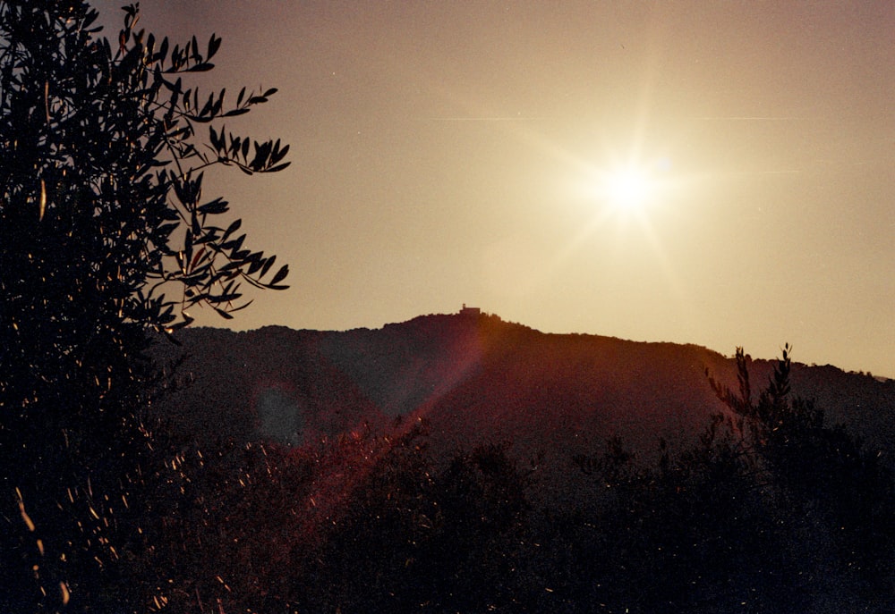 the sun is setting over a mountain range