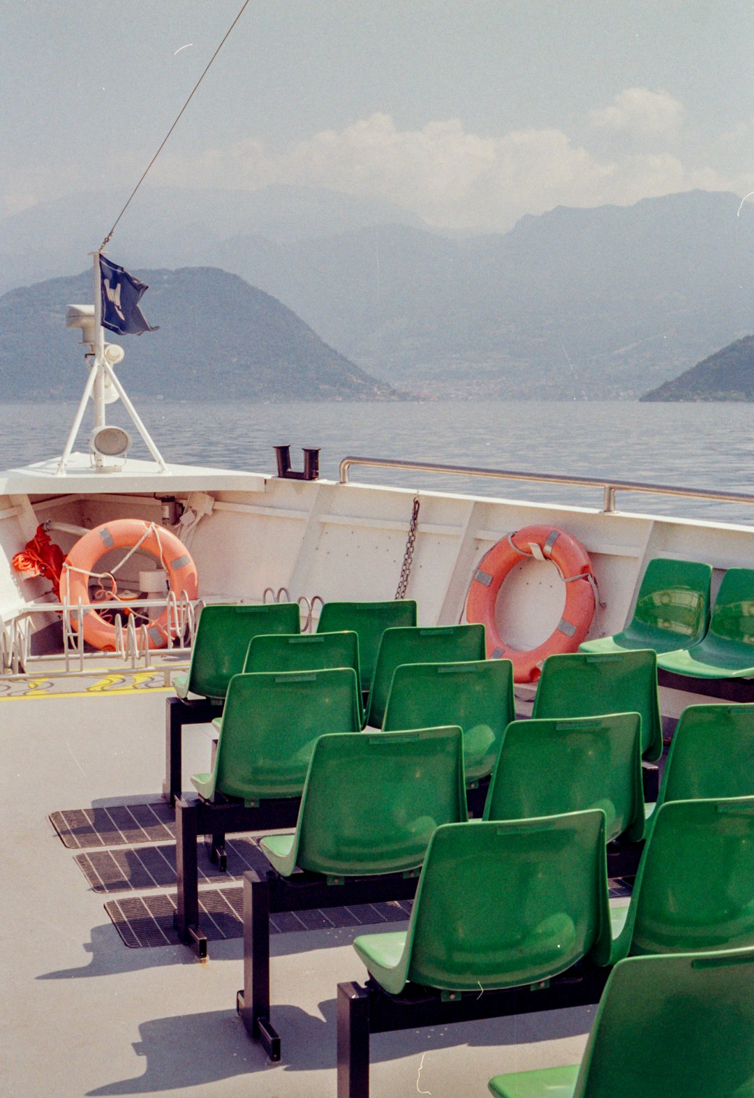 a row of green chairs sitting on top of a boat