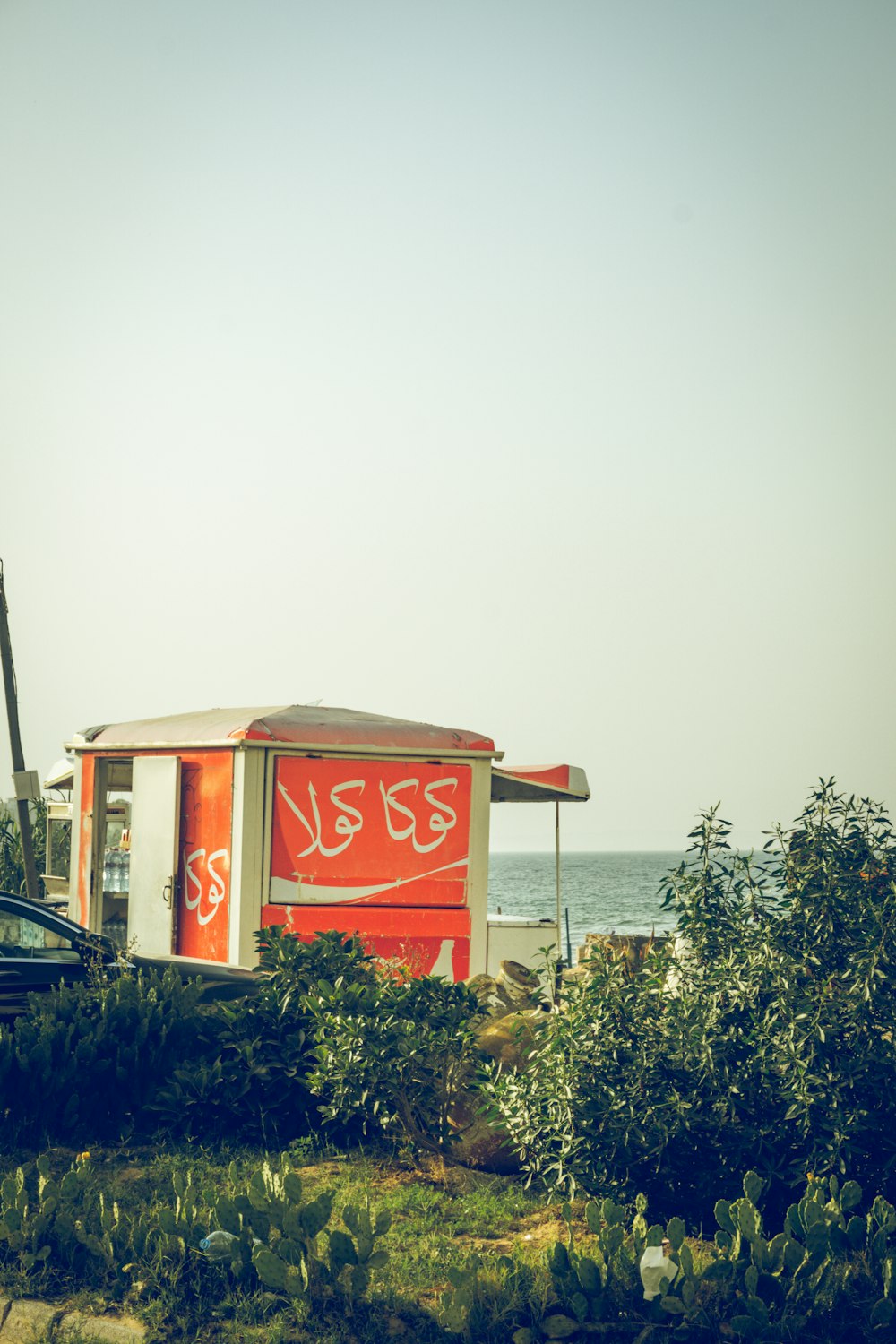 a red and white building sitting on top of a lush green field