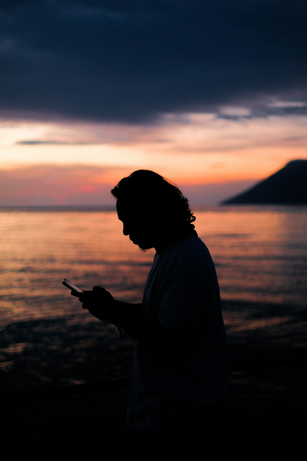 a man standing in front of a body of water