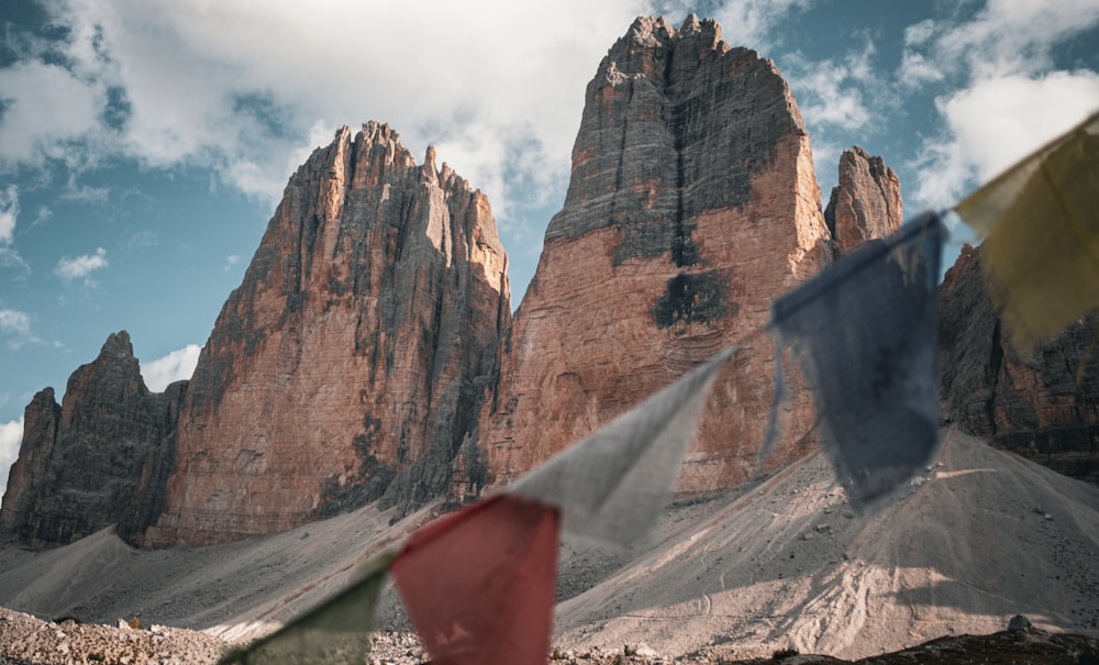 a group of flags flying in front of a mountain range