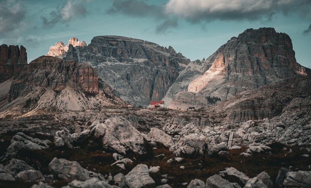 a mountain range with a red house in the middle