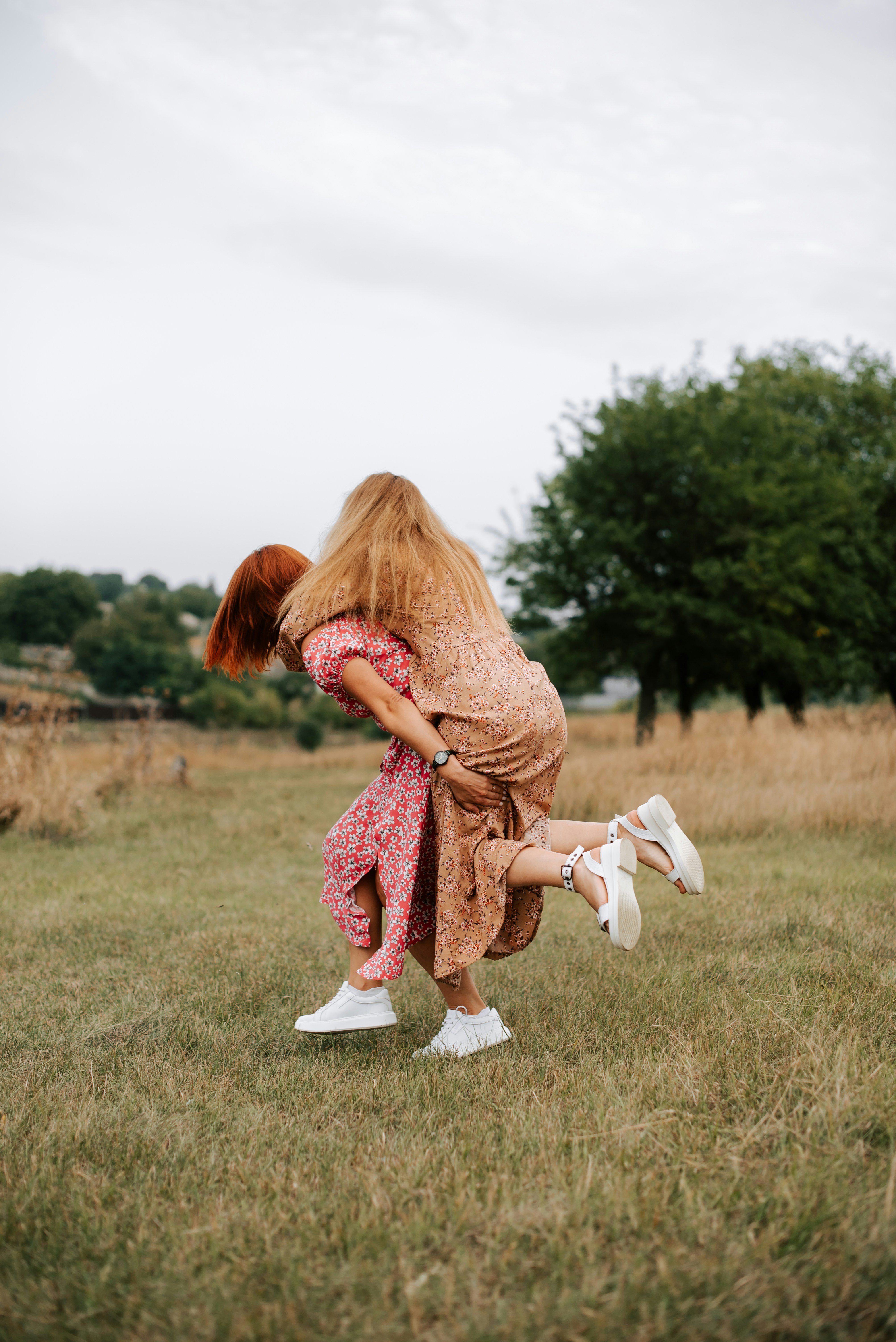 a woman in a dress bending over in a field
