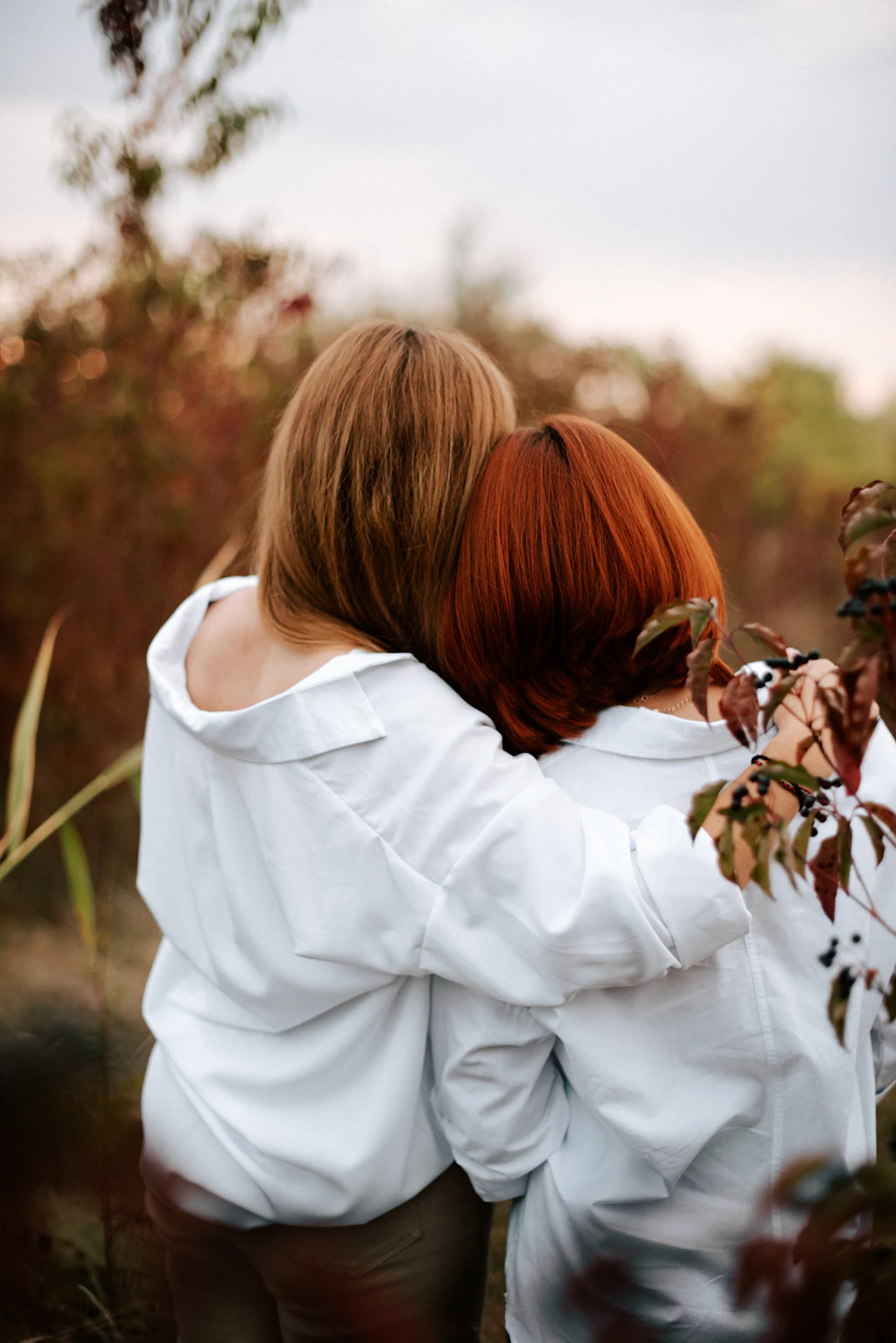 Dos amigas vestidas de blanco se abrazan