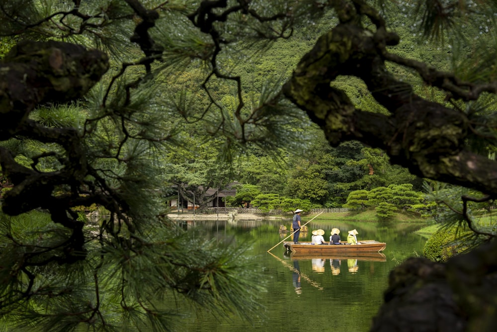 a man in a boat on a lake surrounded by trees