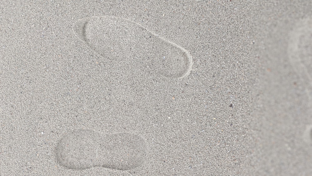 a person's foot prints in the sand