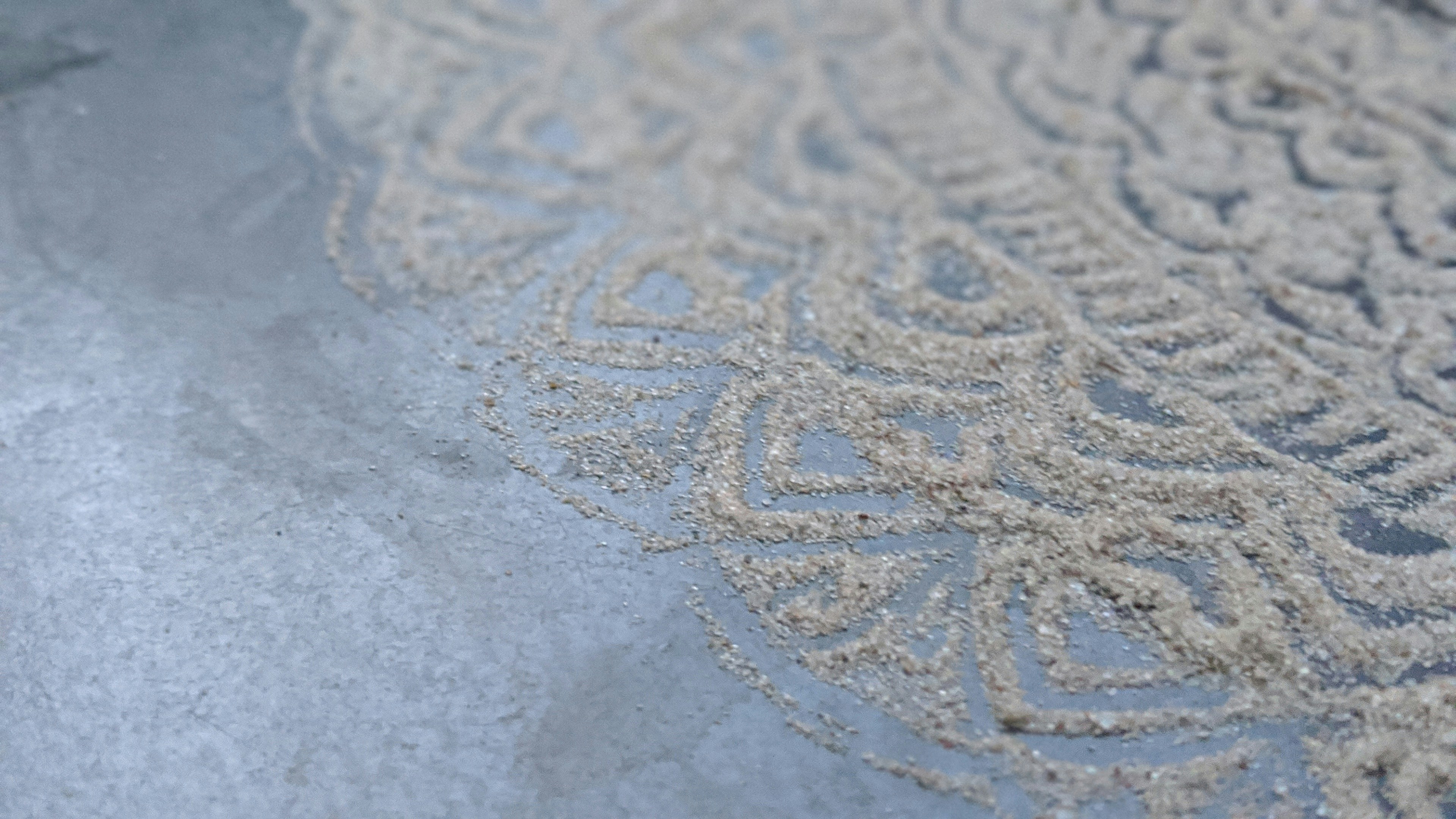 a close up of a sand design on a beach