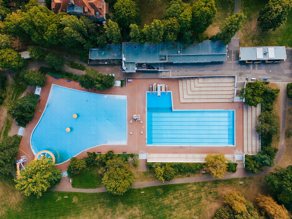 an aerial view of a swimming pool surrounded by trees