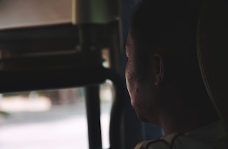 A thoughtful individual looking out a window, symbolizing depression and hope.