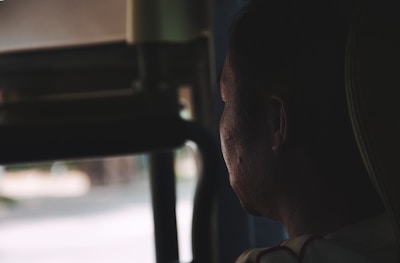 A thoughtful individual looking out a window, symbolizing depression and hope.