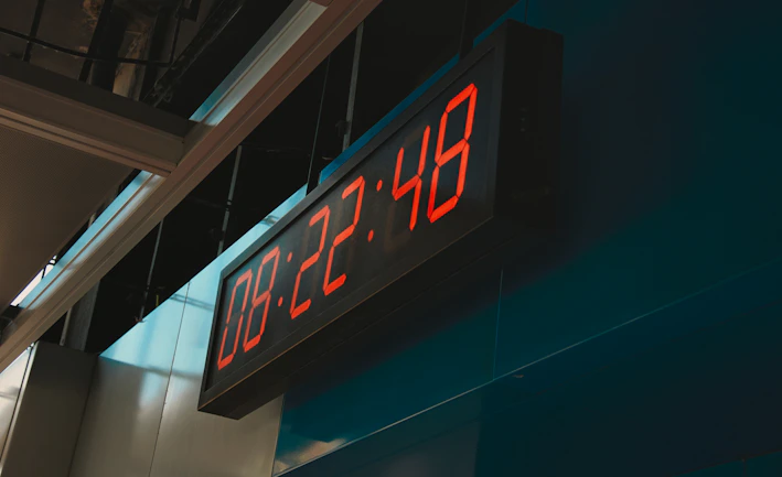 A sleek digital timeclock illuminated by soft ambient lighting on a modern office wall
