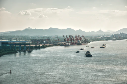 Wide-angle shot of a busy harbor with cranes and ships, featuring visible cable installations