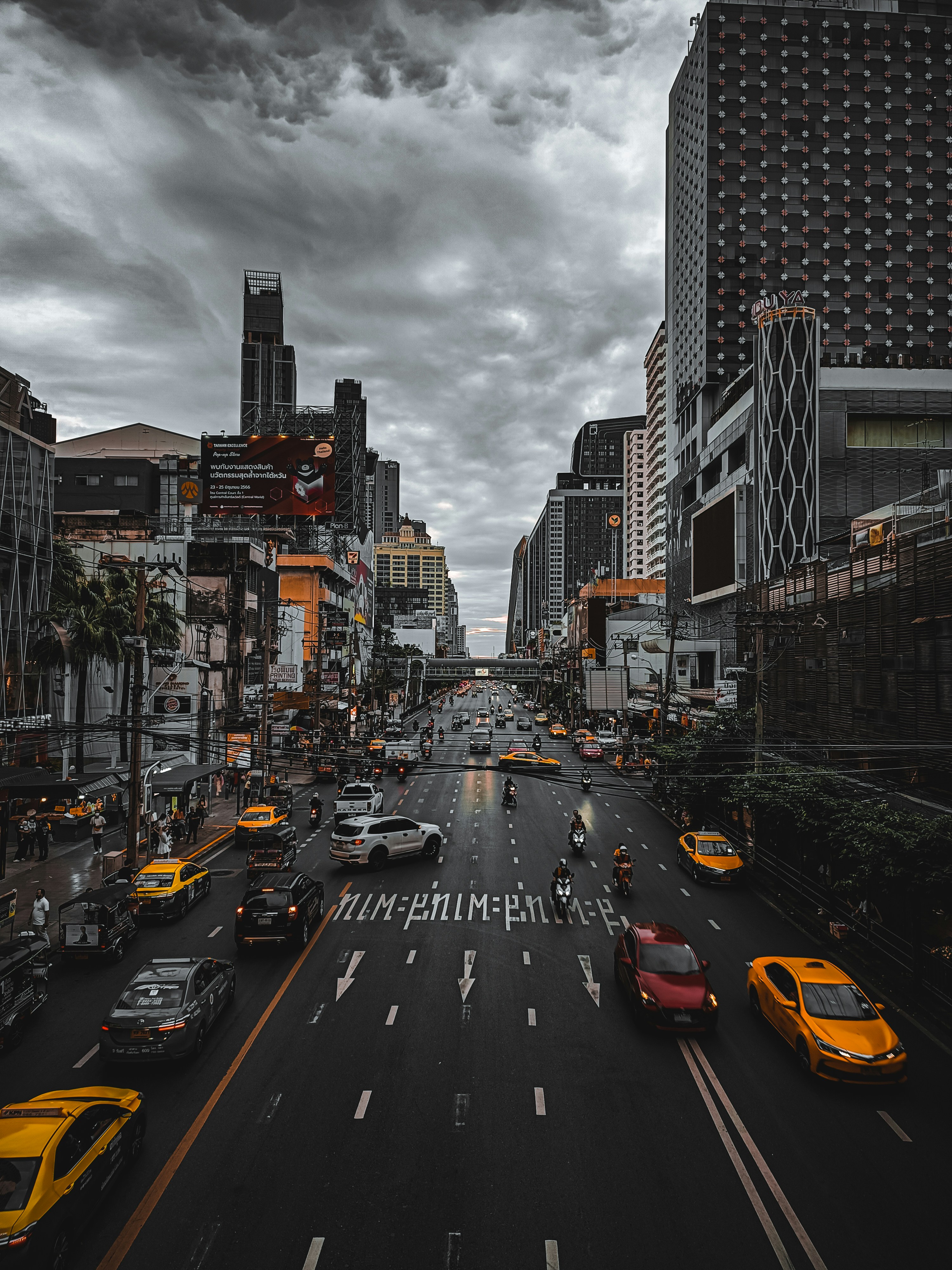 Una calle de la ciudad llena de mucho tráfico bajo un cielo nublado foto –  Imagen de Ciudad gratuita en Unsplash, image size:3000x4000