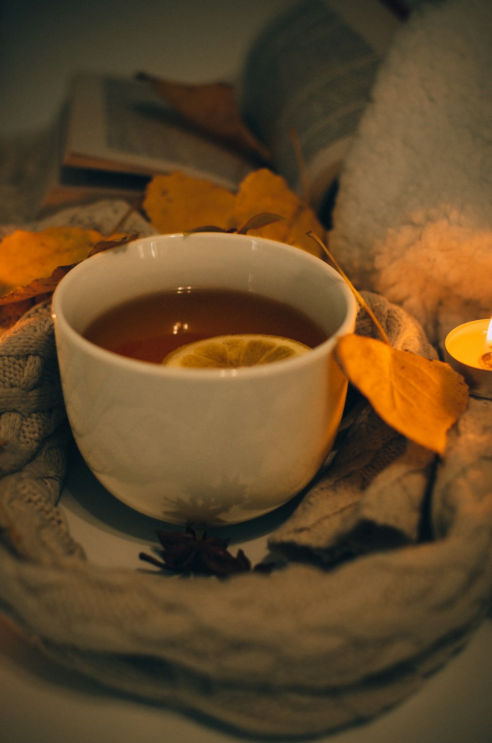 a cup of tea and a candle on a table