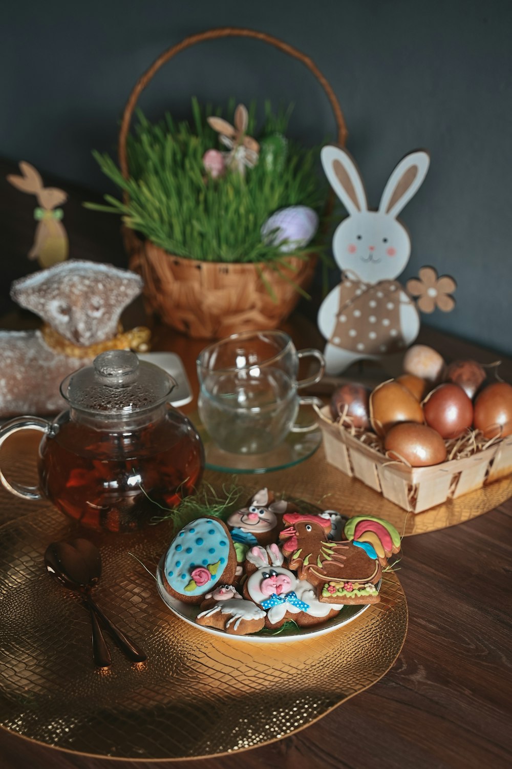 a wooden table topped with a tea pot filled with cookies