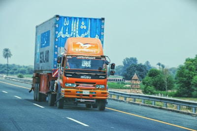 A freight truck loaded with containers driving on a highway