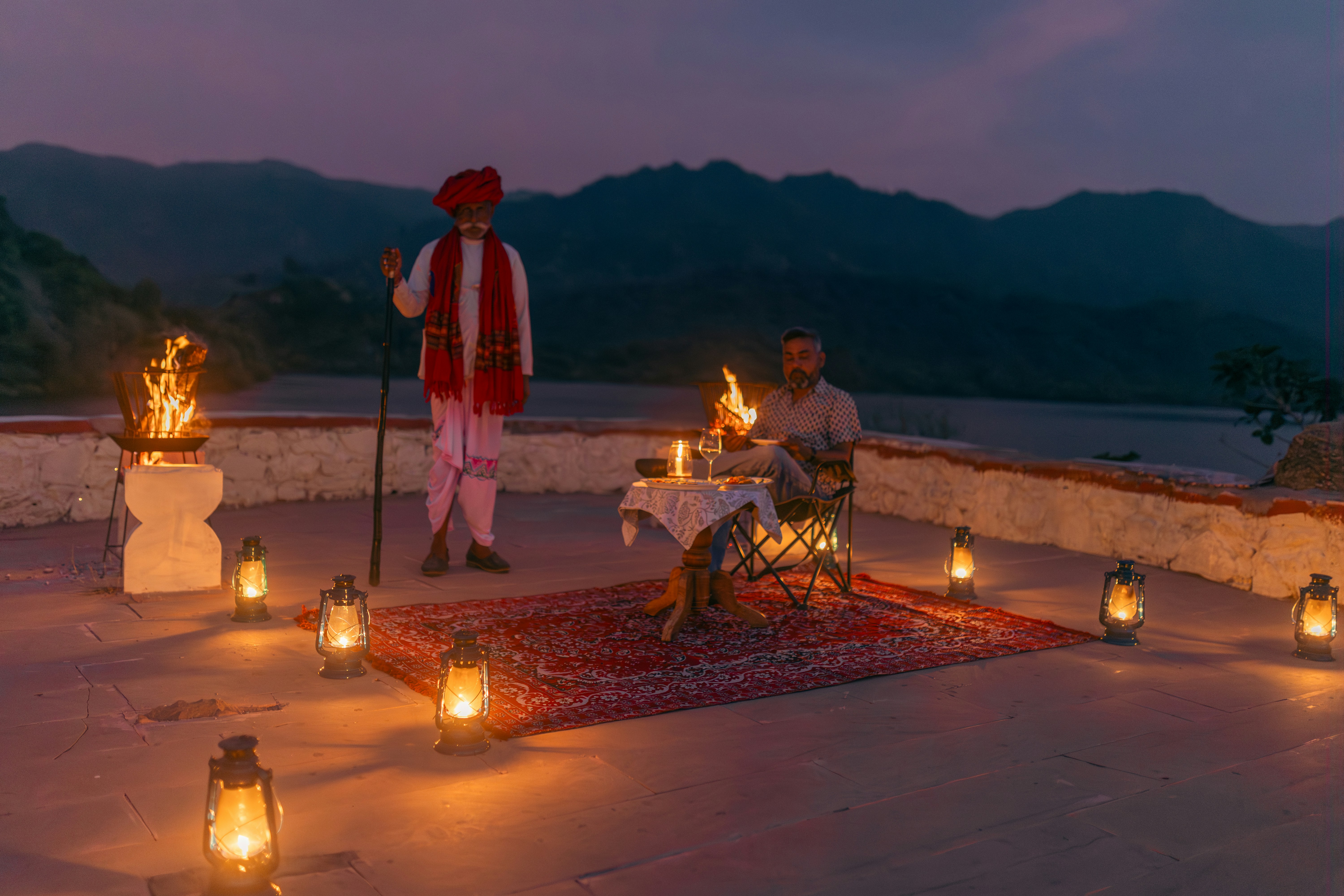 a couple of men sitting on top of a rug