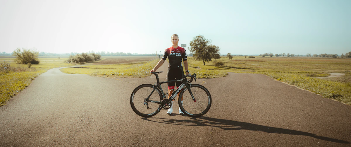 a woman standing next to a bike on a road