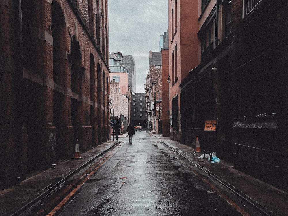 a person walking down a wet alley way