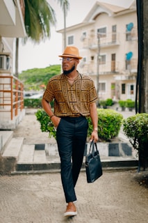 A stylish gentleman wearing a fedora hat while walking through a London street on a crisp day.