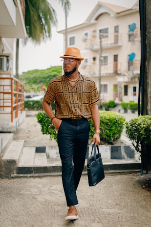 A stylish gentleman wearing a fedora hat while walking through a London street on a crisp day.