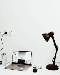 Black and white minimalist workspace with a laptop displaying a carousel design.