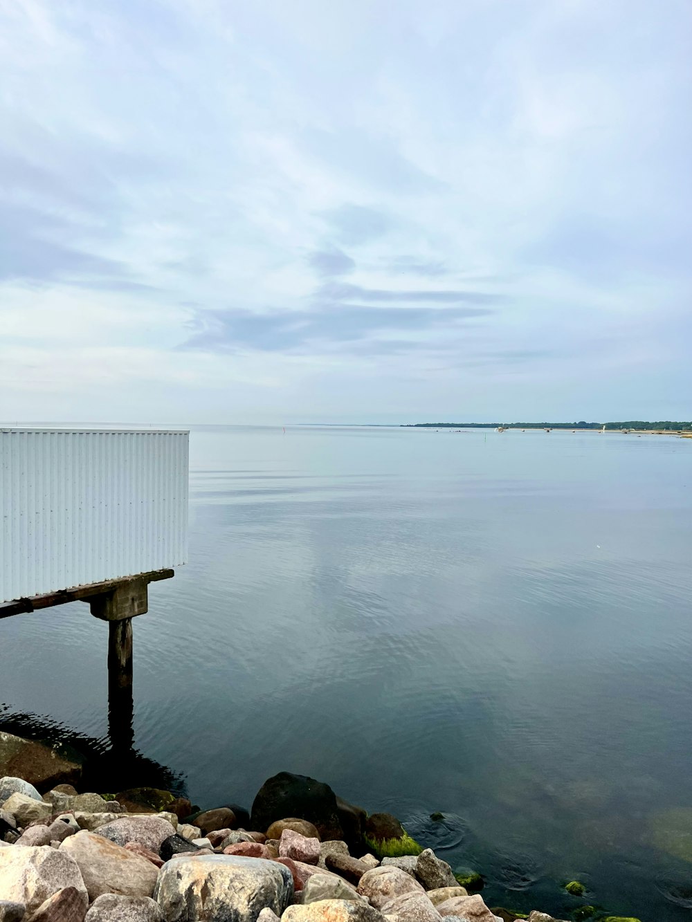 a white building sitting on the edge of a body of water
