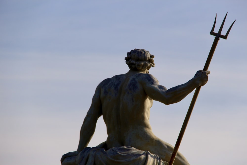 a statue of a man holding a pitchfork