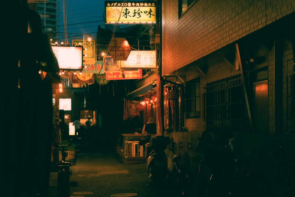 une ruelle étroite avec une enseigne au néon au-dessus