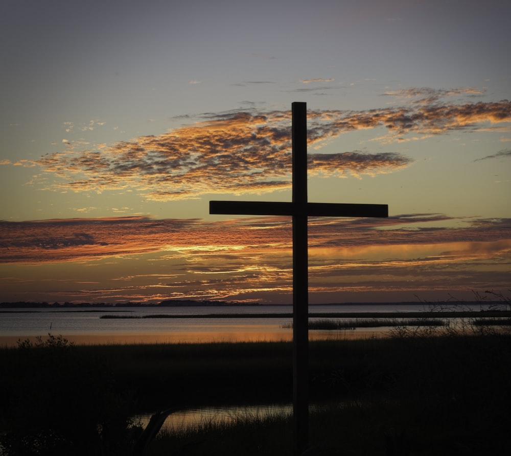 a wooden cross sitting on top of a lush green field