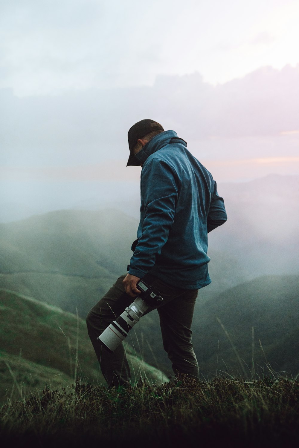 a man standing on top of a lush green hillside