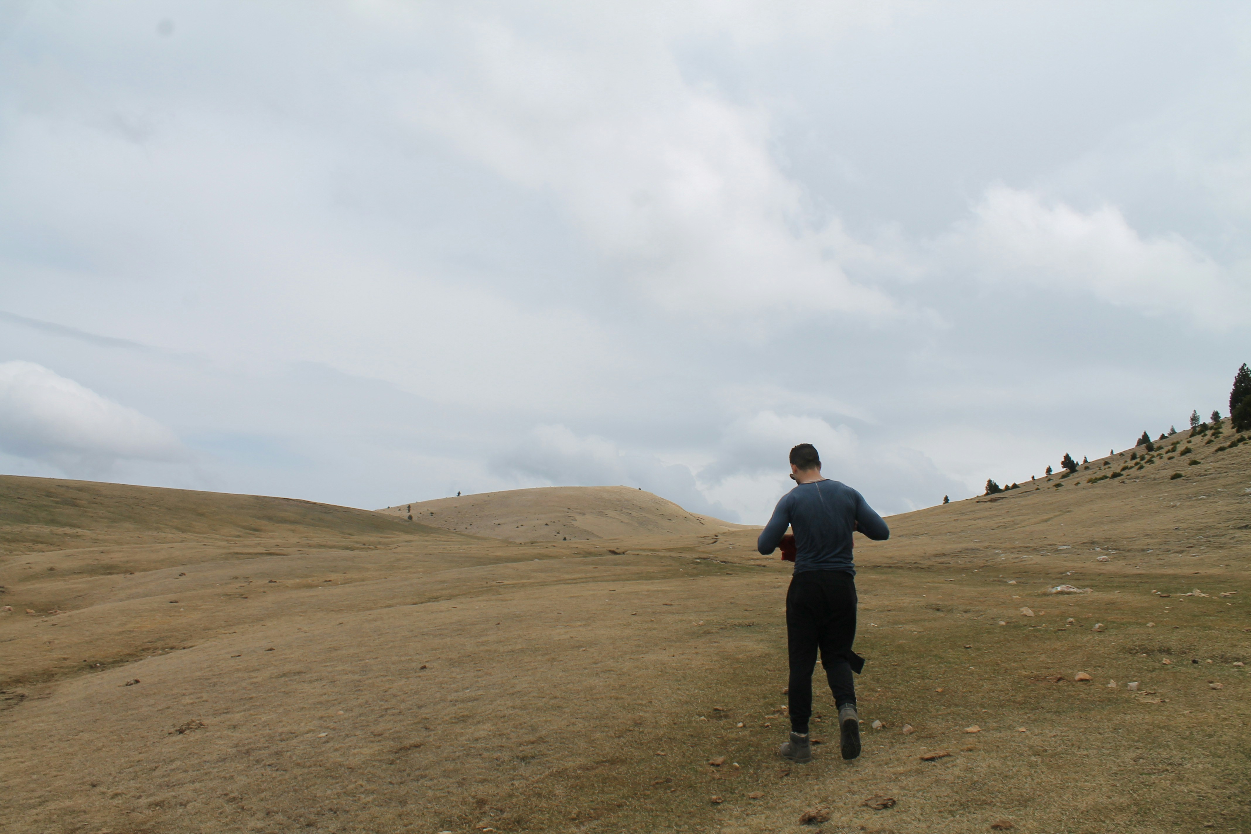 a man running in a field on a cloudy day