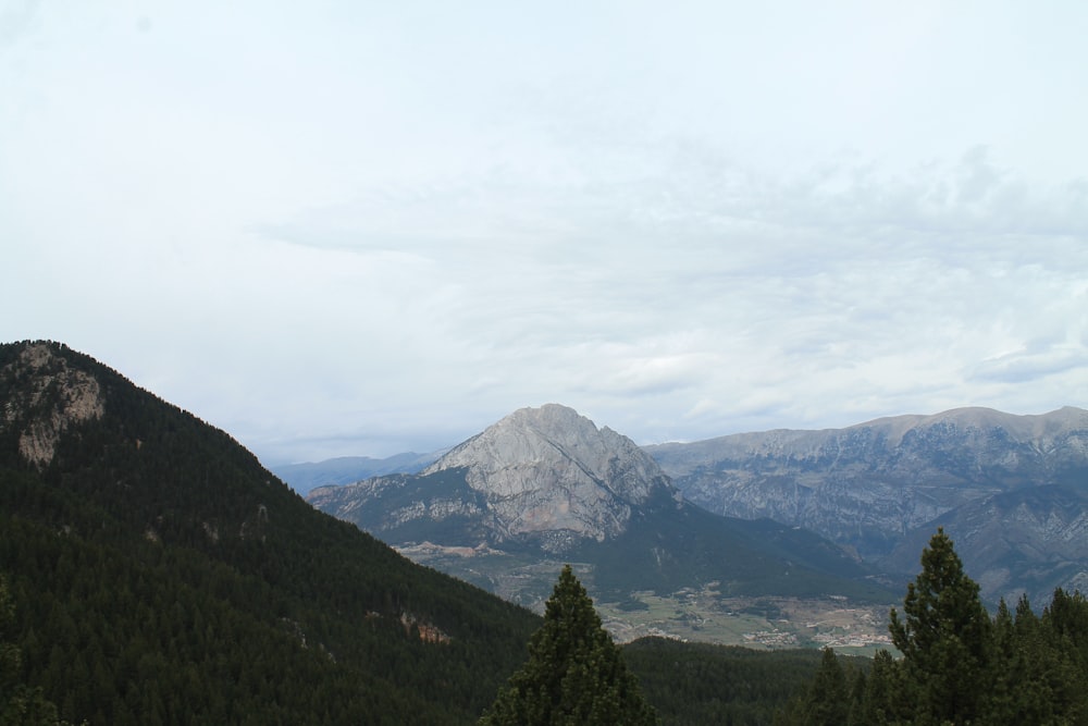 a view of a mountain range with trees in the foreground