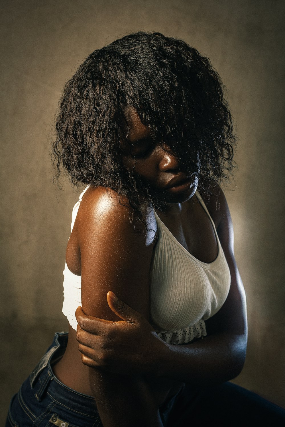 a woman in a white tank top and jeans