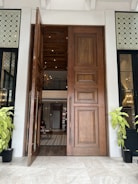 Double large wooden doors opening to a bright, spacious room.