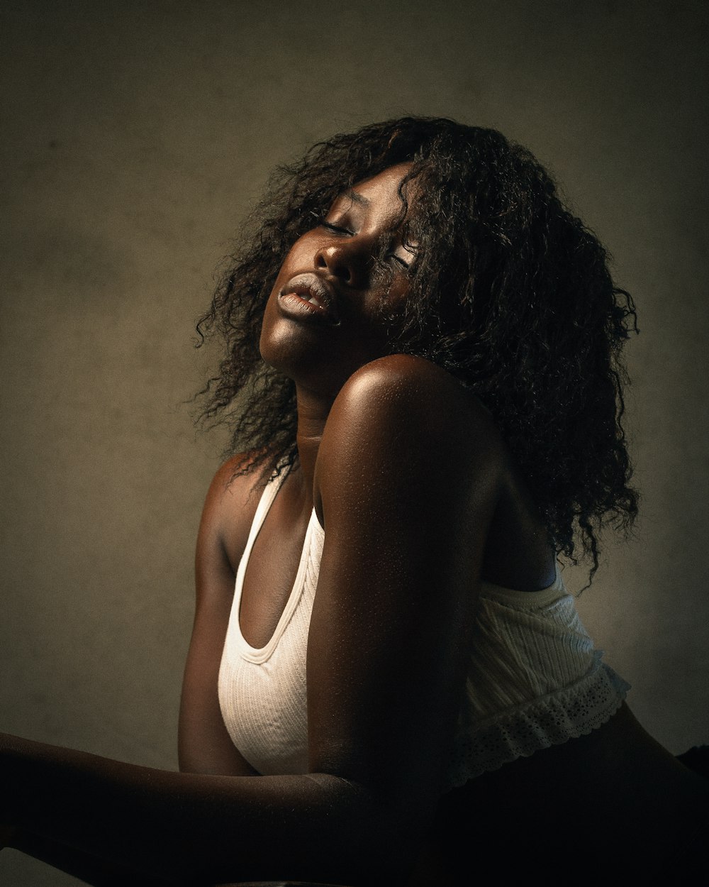 a woman in a white tank top posing for a picture