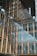 A modern architectural building features a facade with large glass windows and gold-colored metal frames. The design includes overlapping structures and reflective surfaces, creating a sense of depth and modernity.