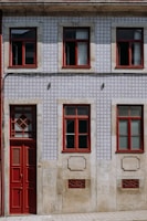 a building with a red door and two windows