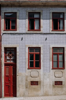 a building with a red door and two windows
