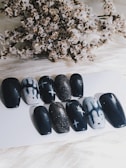 a bunch of black and white nails sitting on top of a table