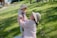 A smiling mother holding her healthy baby in a sunlit park.
