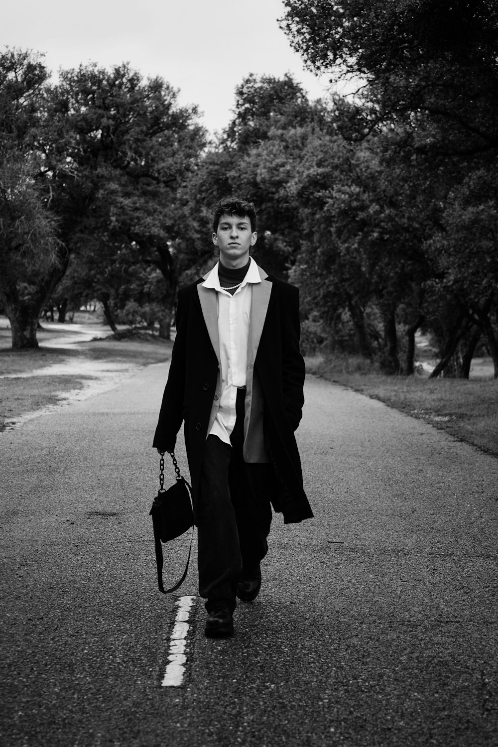 a man walking down a street holding a tennis racquet