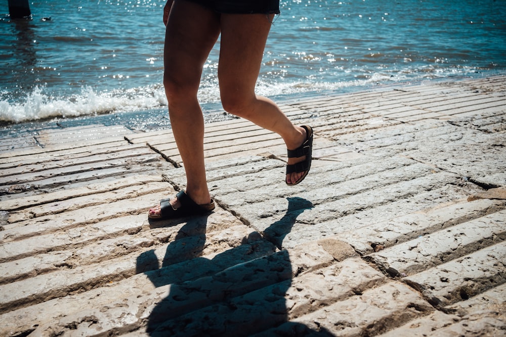 a woman is running on a pier near the water