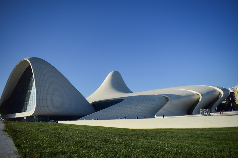 a large white building sitting on top of a lush green field